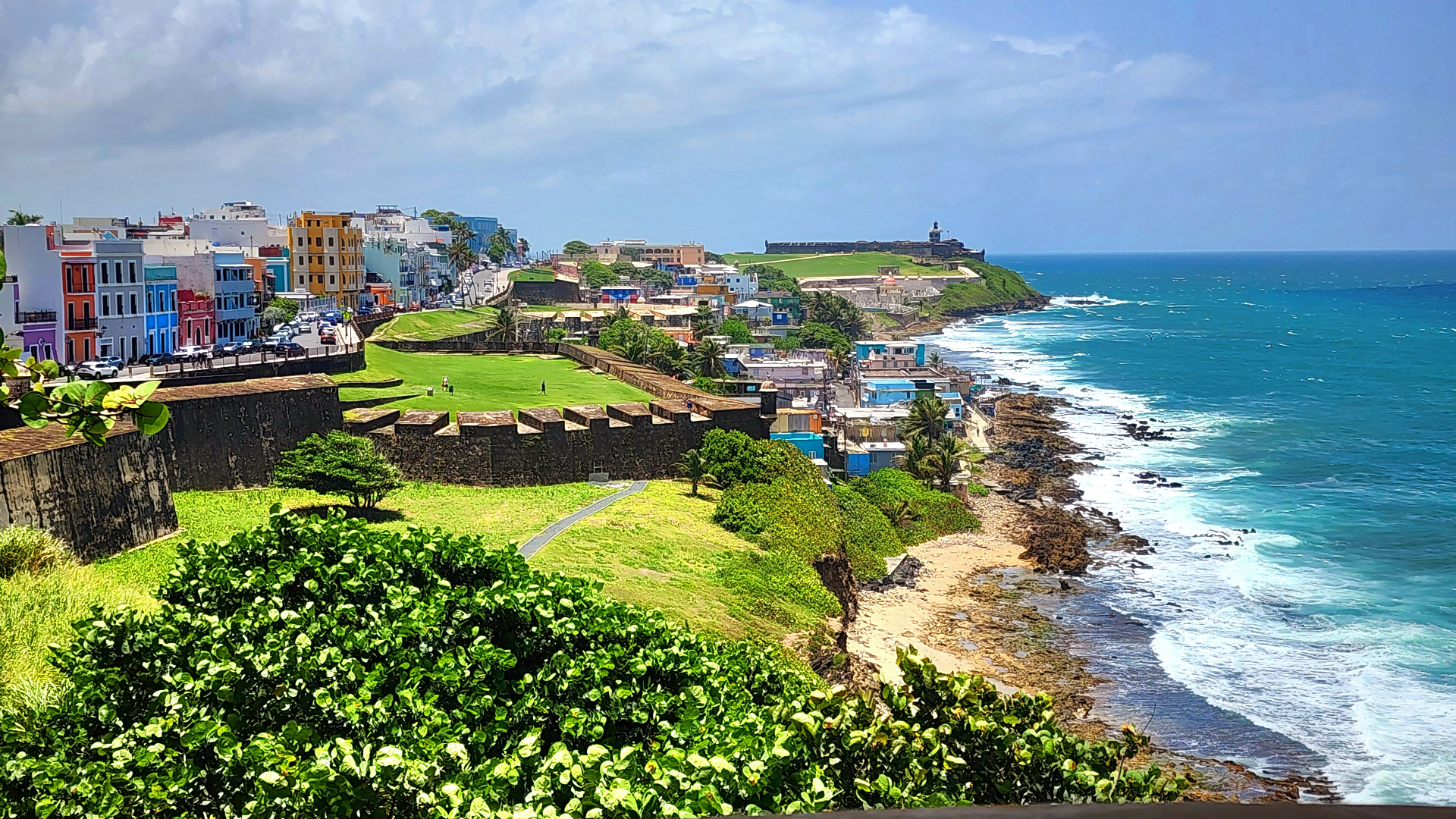 Colonial cobblestone street in Old San Juan lined with colorful buildings and iron balconies